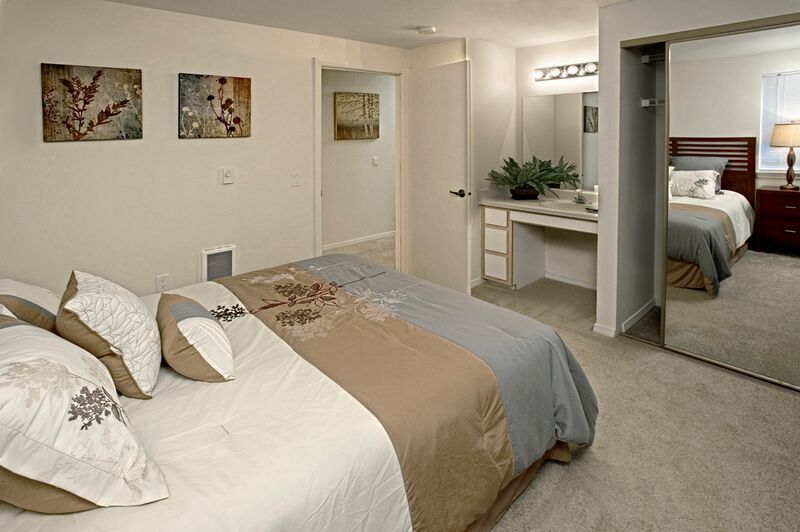 A bedroom with a large bed and a mirror