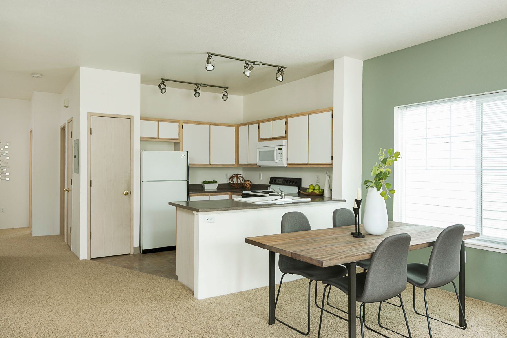 A kitchen and dining room in a house with a table and chairs.
