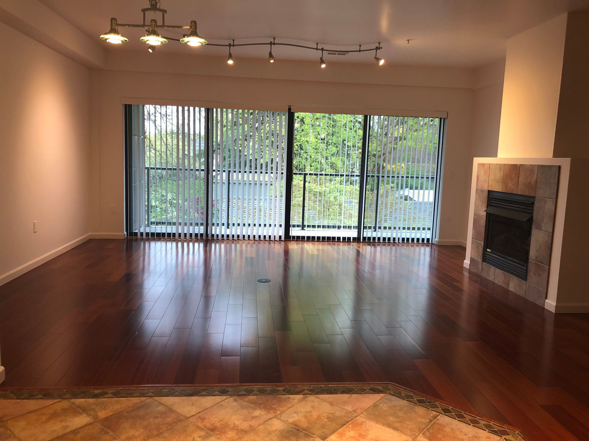 An empty living room with a fireplace and sliding glass doors