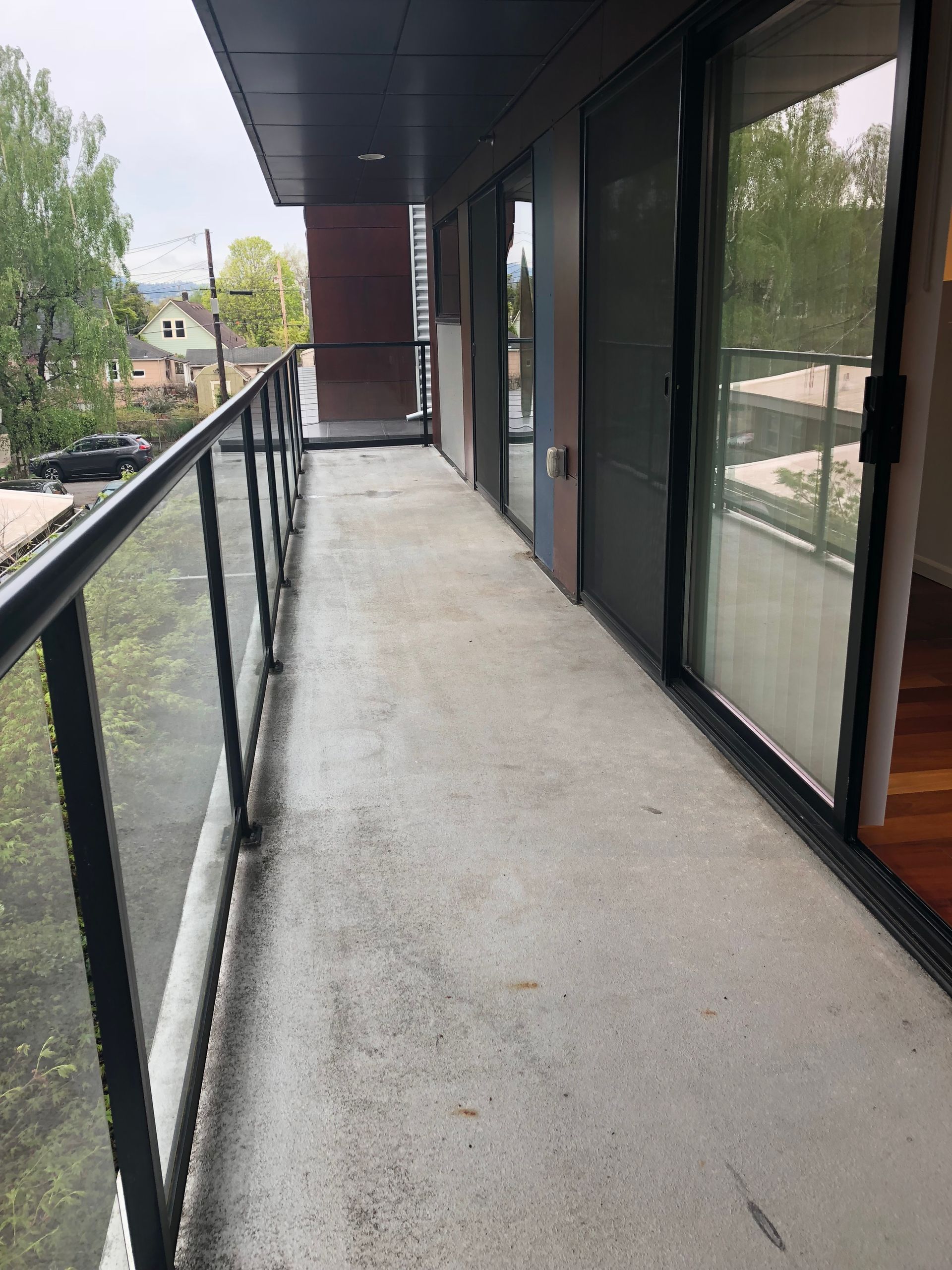 A balcony with a glass railing and sliding glass doors