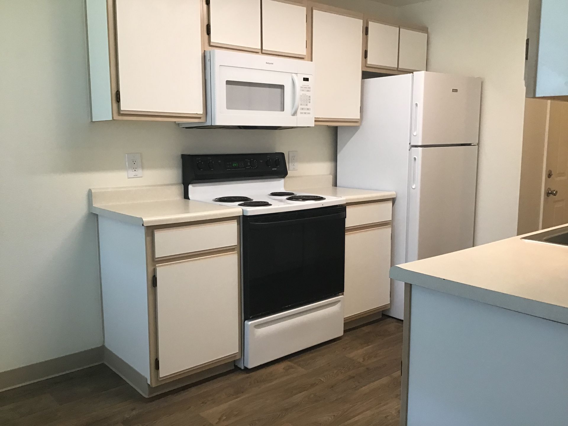 A kitchen with a stove , refrigerator and microwave
