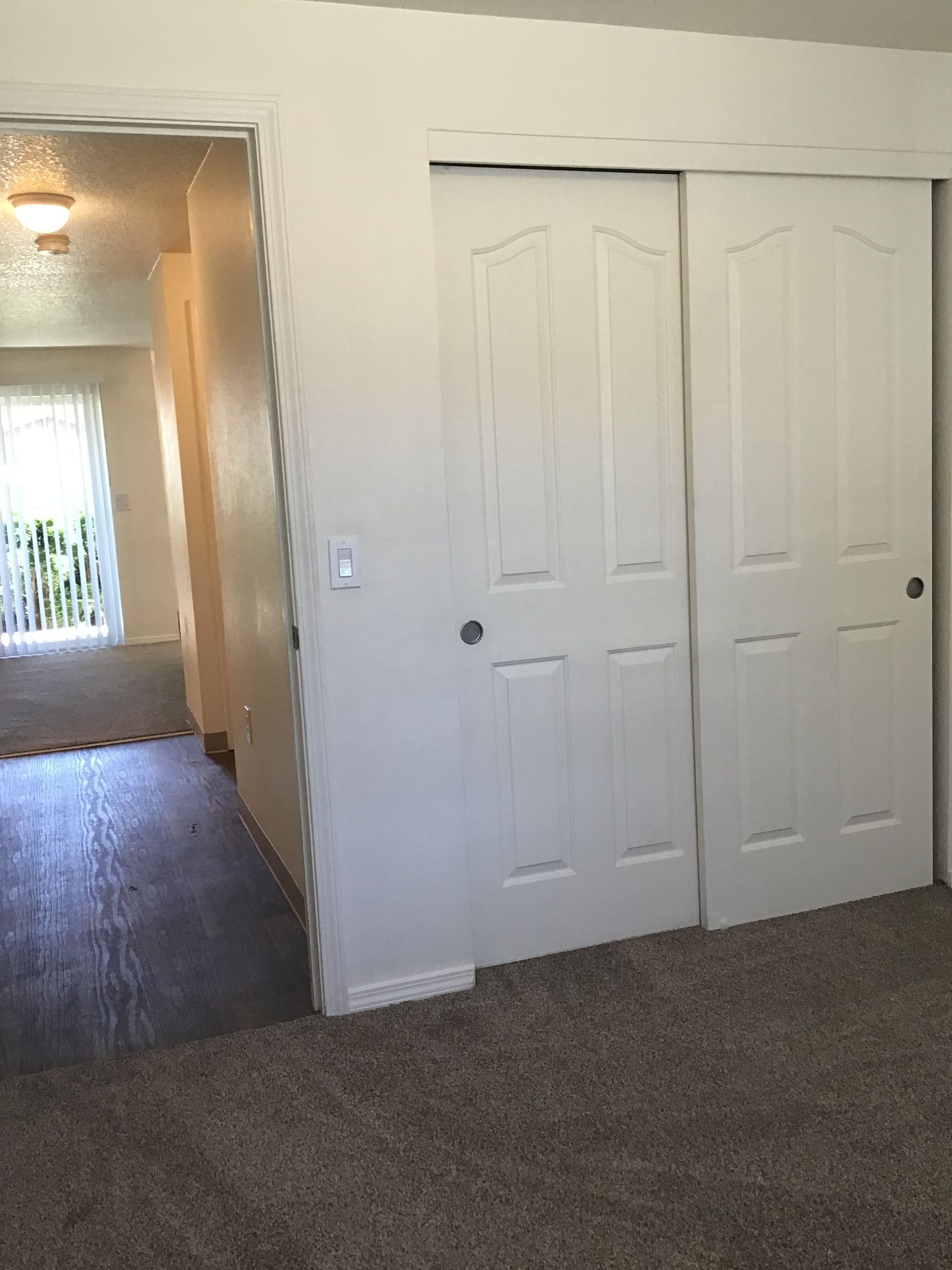 A bedroom with a closet and a window.
