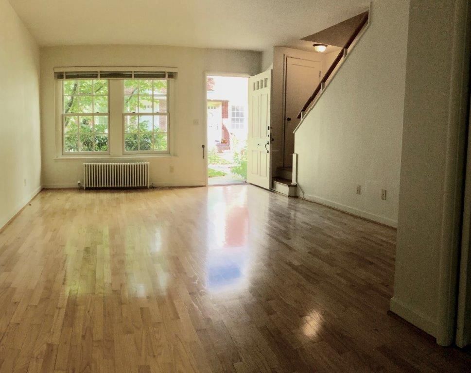 An empty living room with hardwood floors and stairs