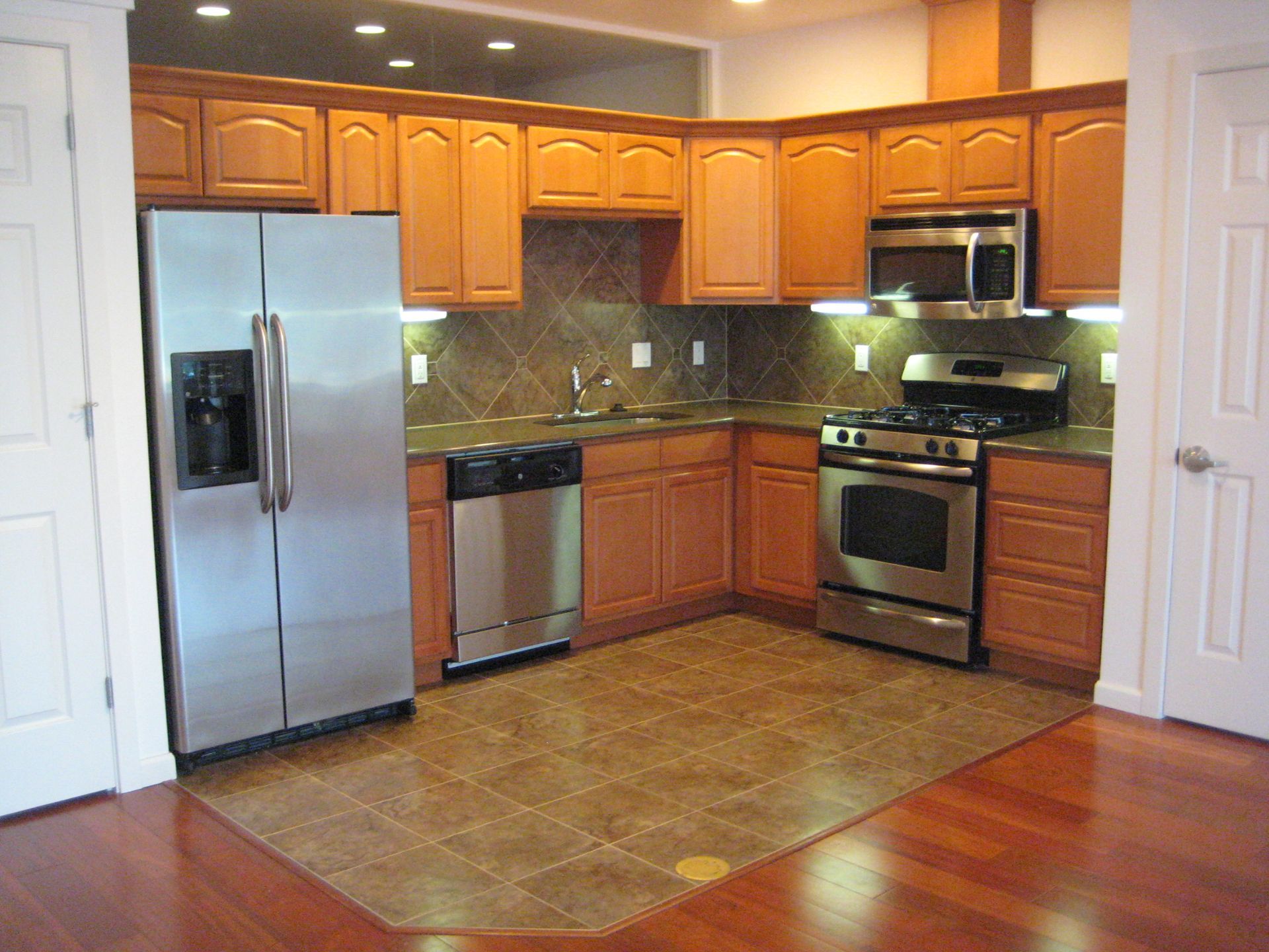 A kitchen with stainless steel appliances and wooden cabinets