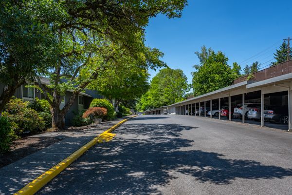 A row of parking garages with cars parked in them in a residential area.