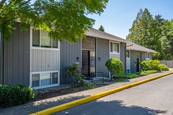 A row of apartment buildings with a yellow curb on the side of the road.