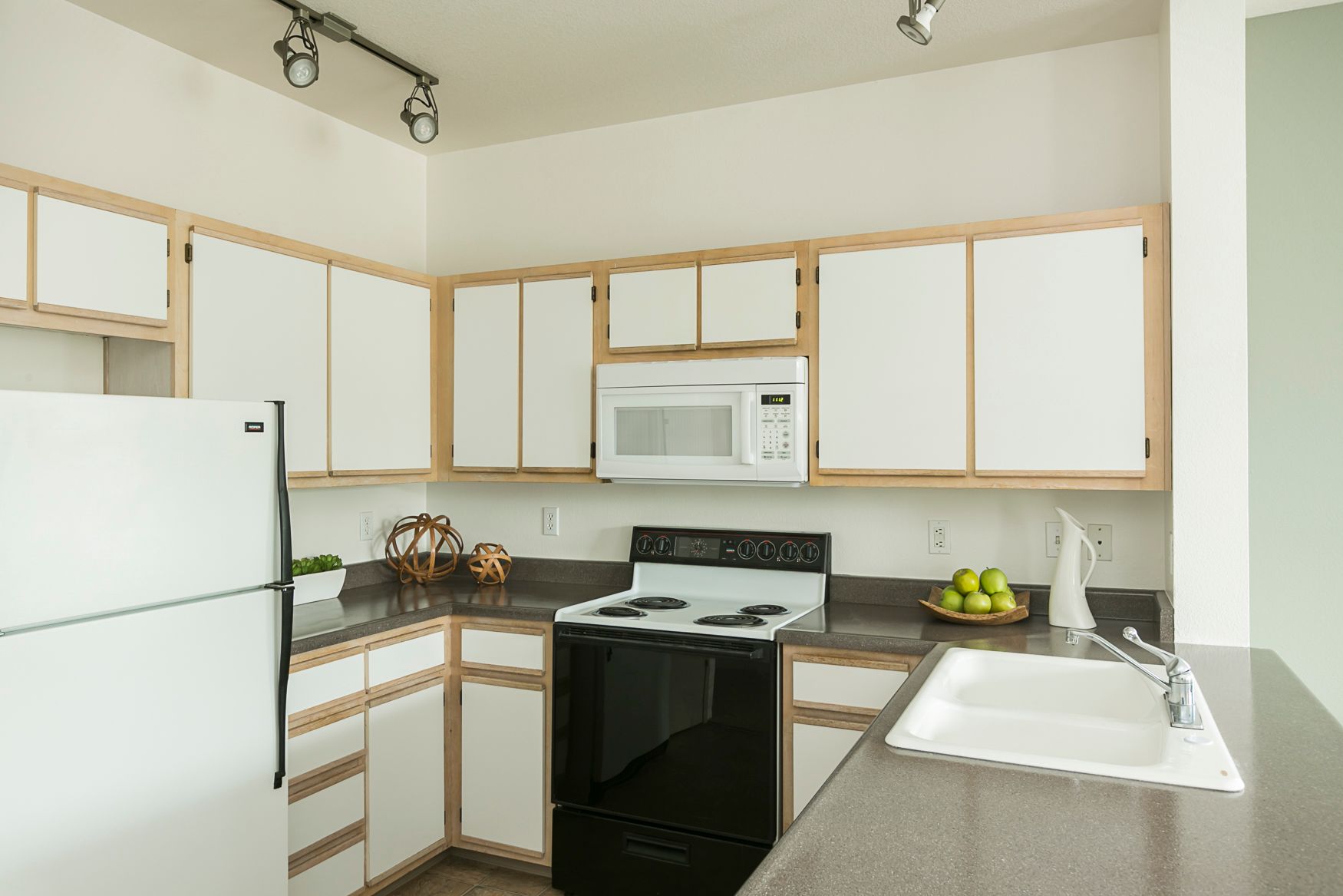 A kitchen with white cabinets and black appliances