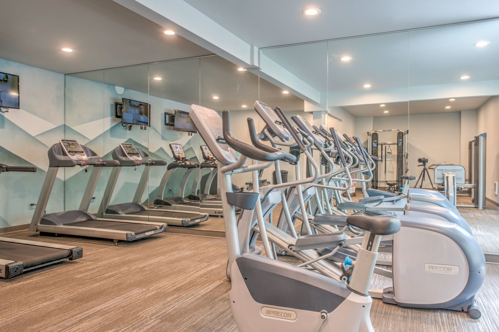 A gym with a lot of treadmills and exercise bikes.