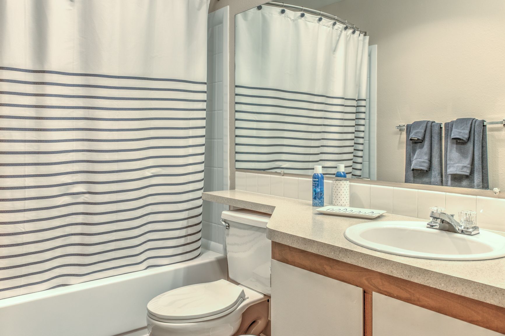 A bathroom with a toilet , sink , and shower curtain.