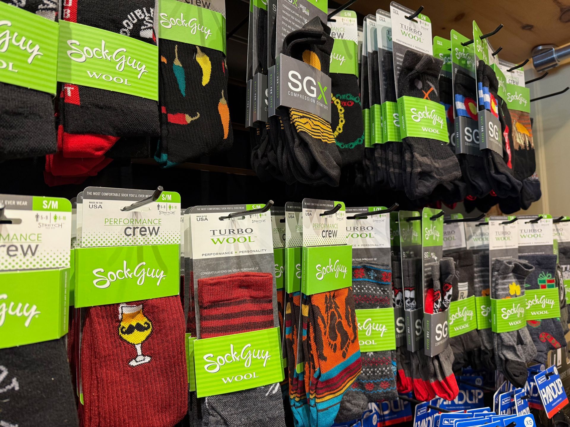 A variety of socks are lined up on a shelf in a store.