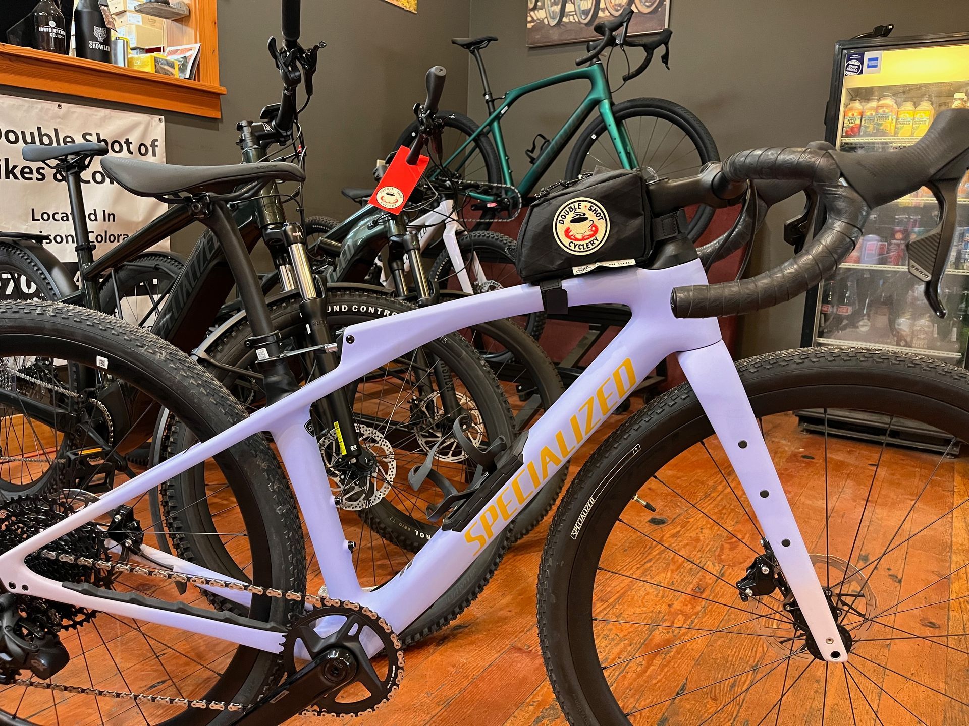 A purple specialized bike is sitting on a wooden floor next to other bikes.