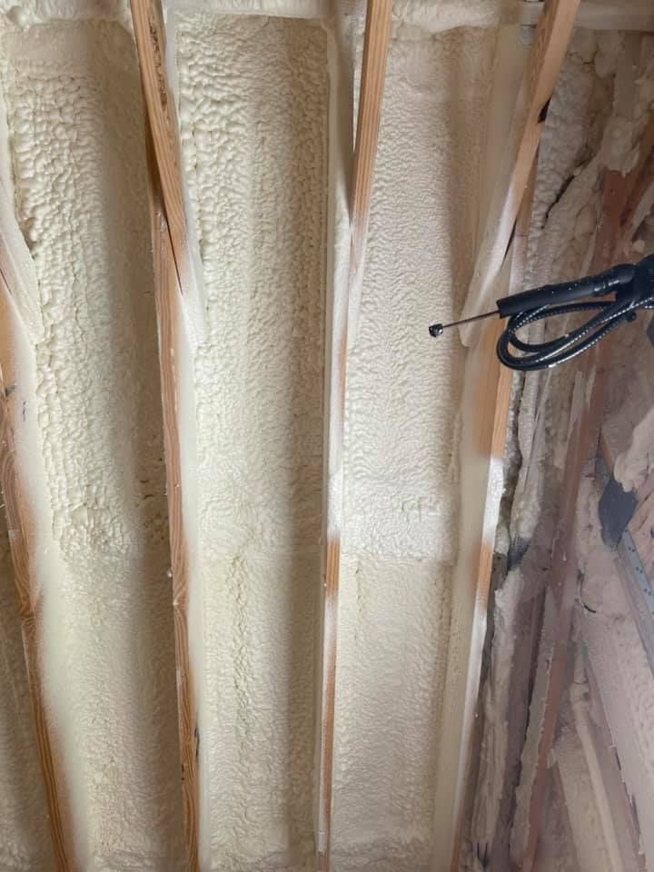 Spray foam insulation being applied to rafters.