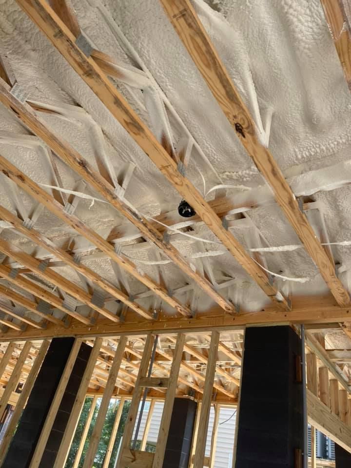Wooden rafters with spray foam insulation, construction site.