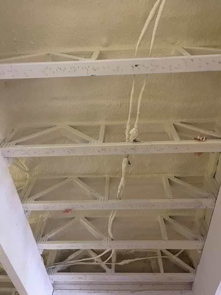 White insulated ceiling with wooden beams, electrical wires.