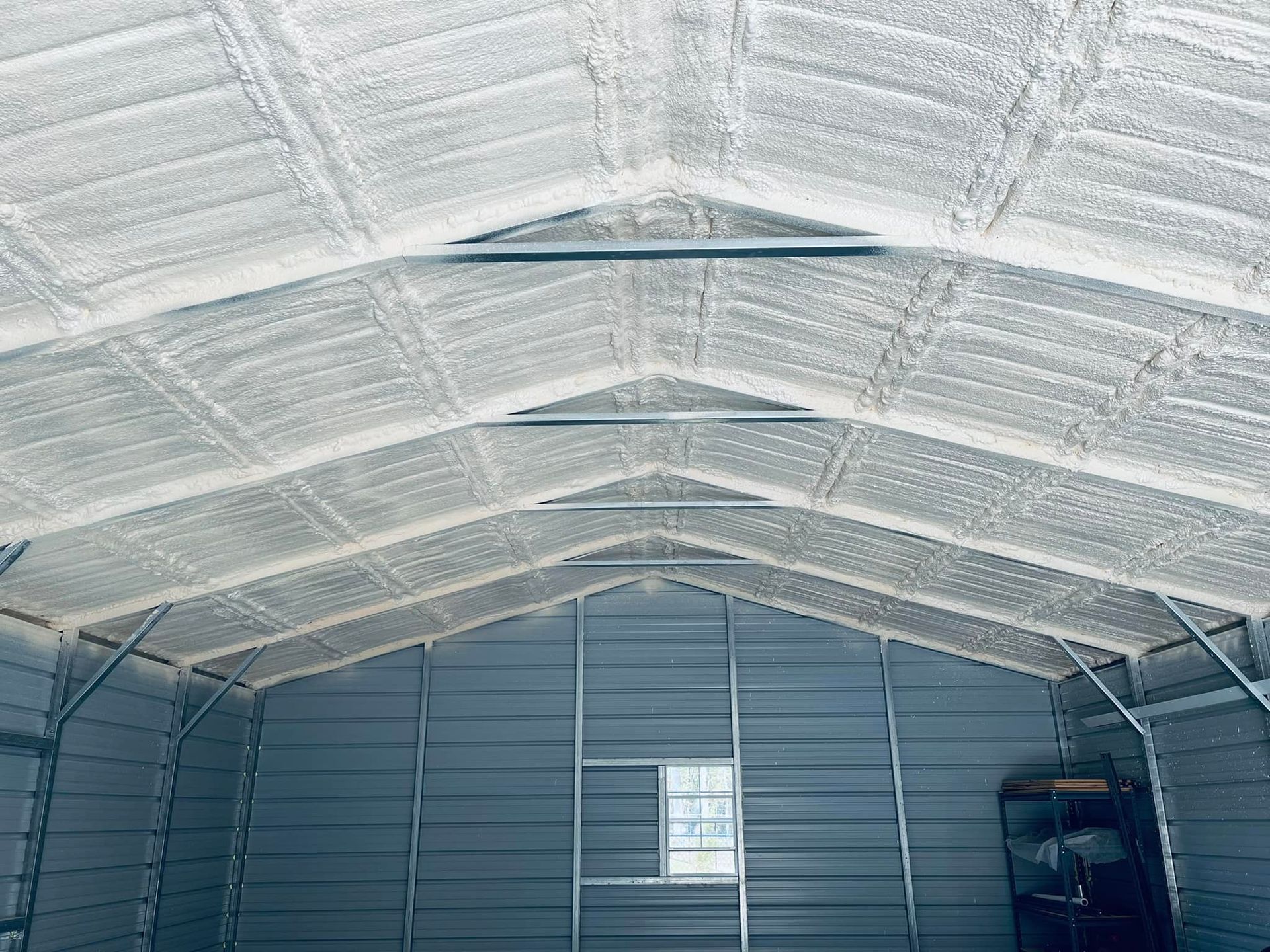 Interior of a metal building with spray foam insulation on the roof.