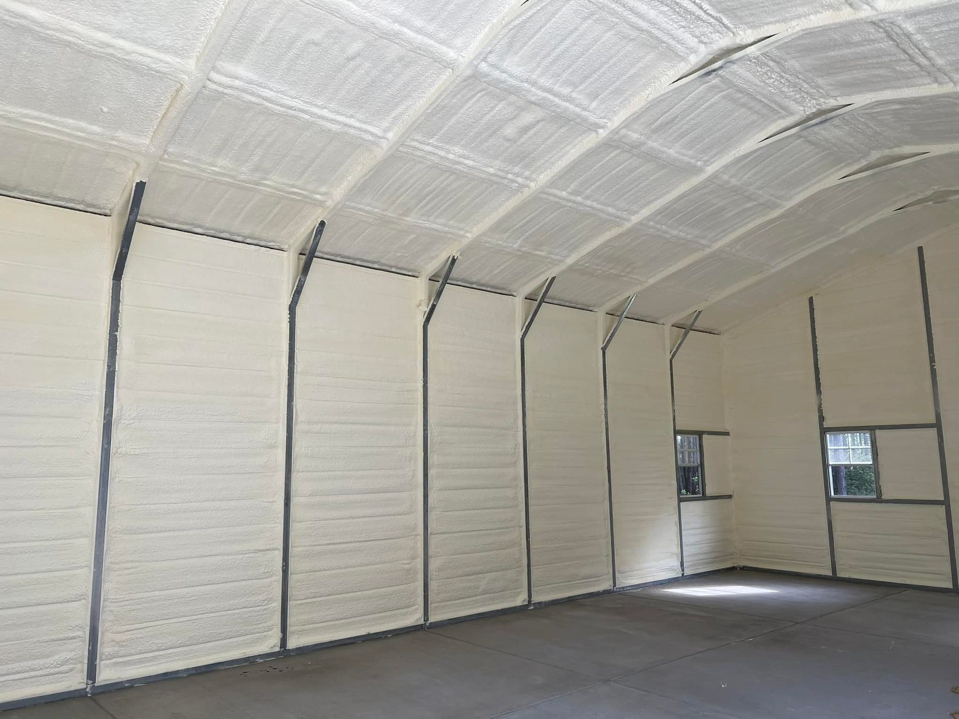 Interior of a building insulated with white spray foam on walls and ceiling.