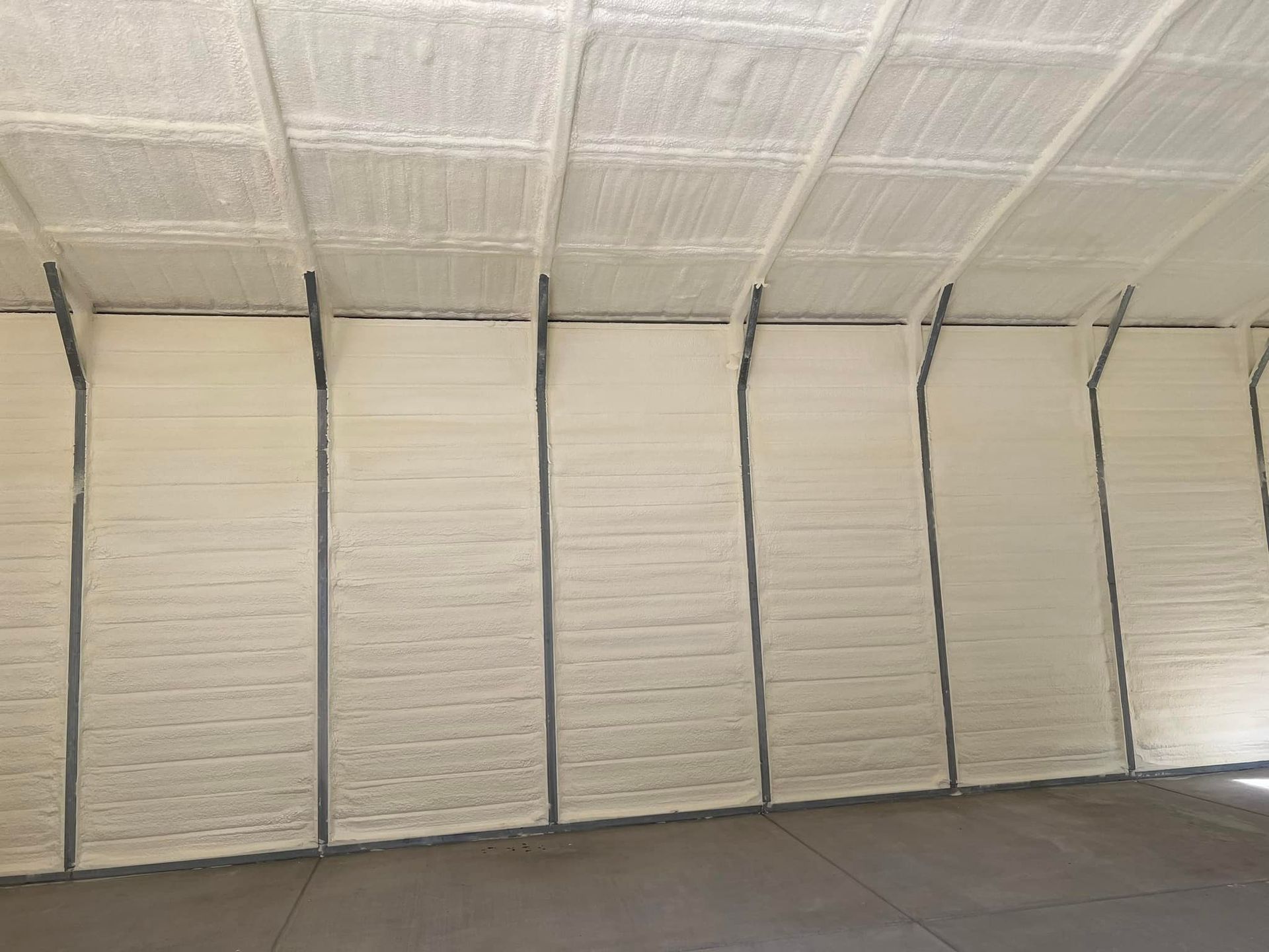 Interior view of a building with spray foam insulation on the walls and ceiling.