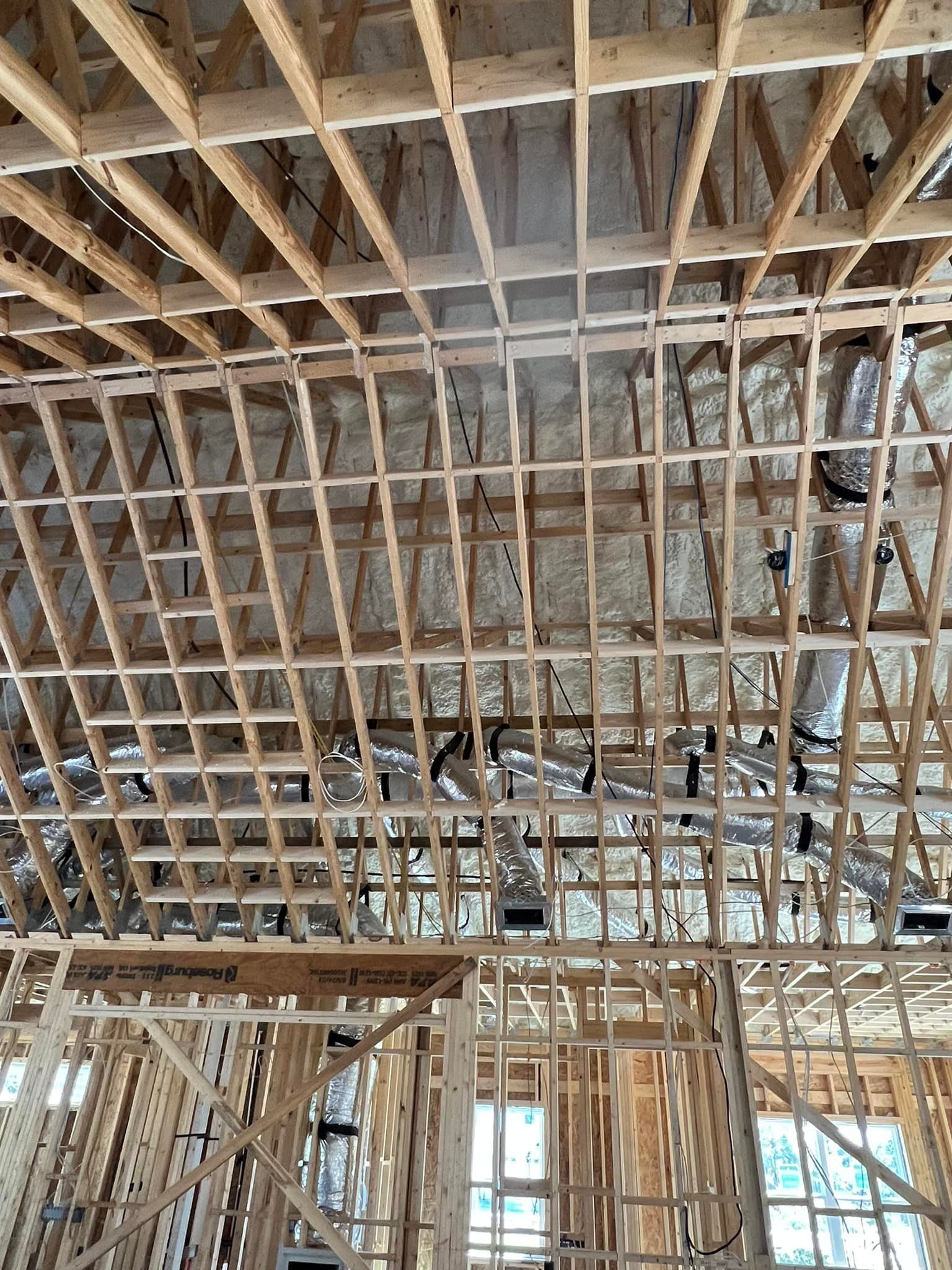 Wooden framework of a building's roof and walls under construction.