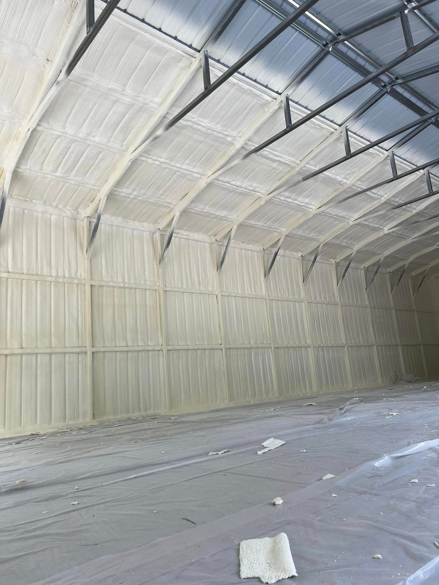 Interior of a large building with walls and ceiling insulated with white foam.
