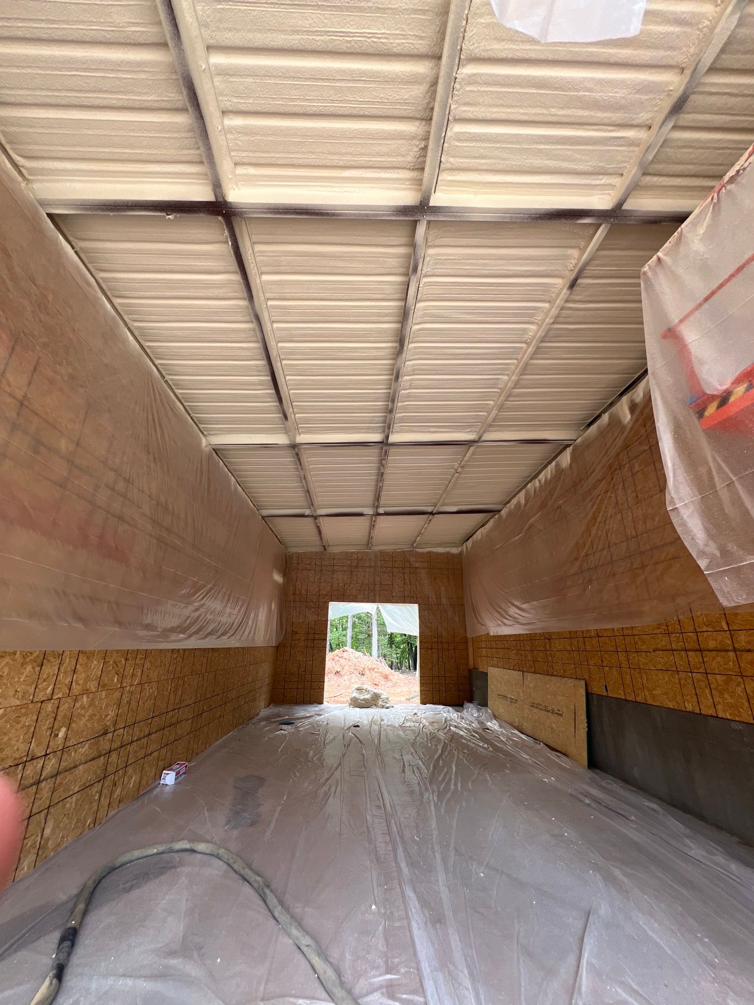 Interior of a building under construction. Walls and ceiling lined with wood and insulation.
