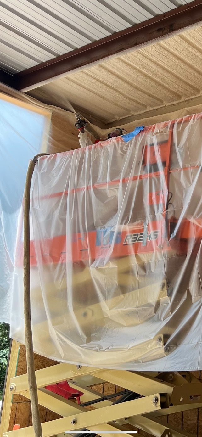 A covered orange lift is next to wooden supports under a metal roof.