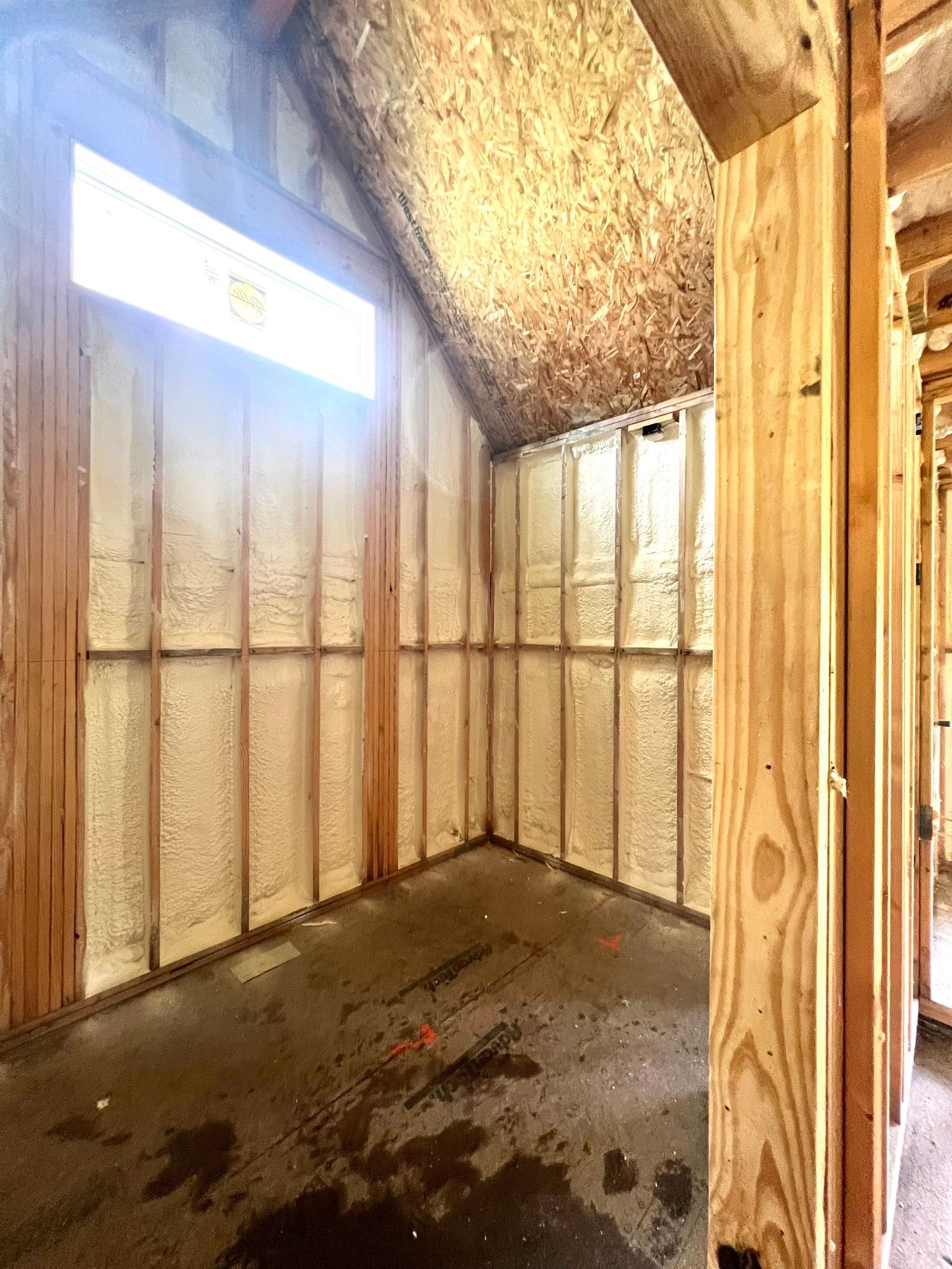 Interior construction: walls sprayed with insulation, unfinished wood framing.