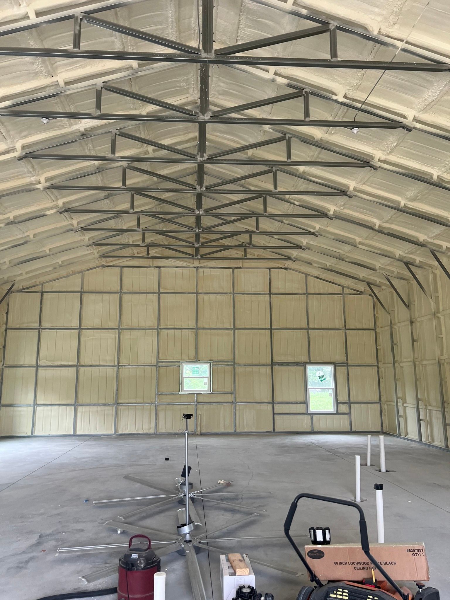 Interior of a metal building with spray foam insulation on the walls and ceiling.