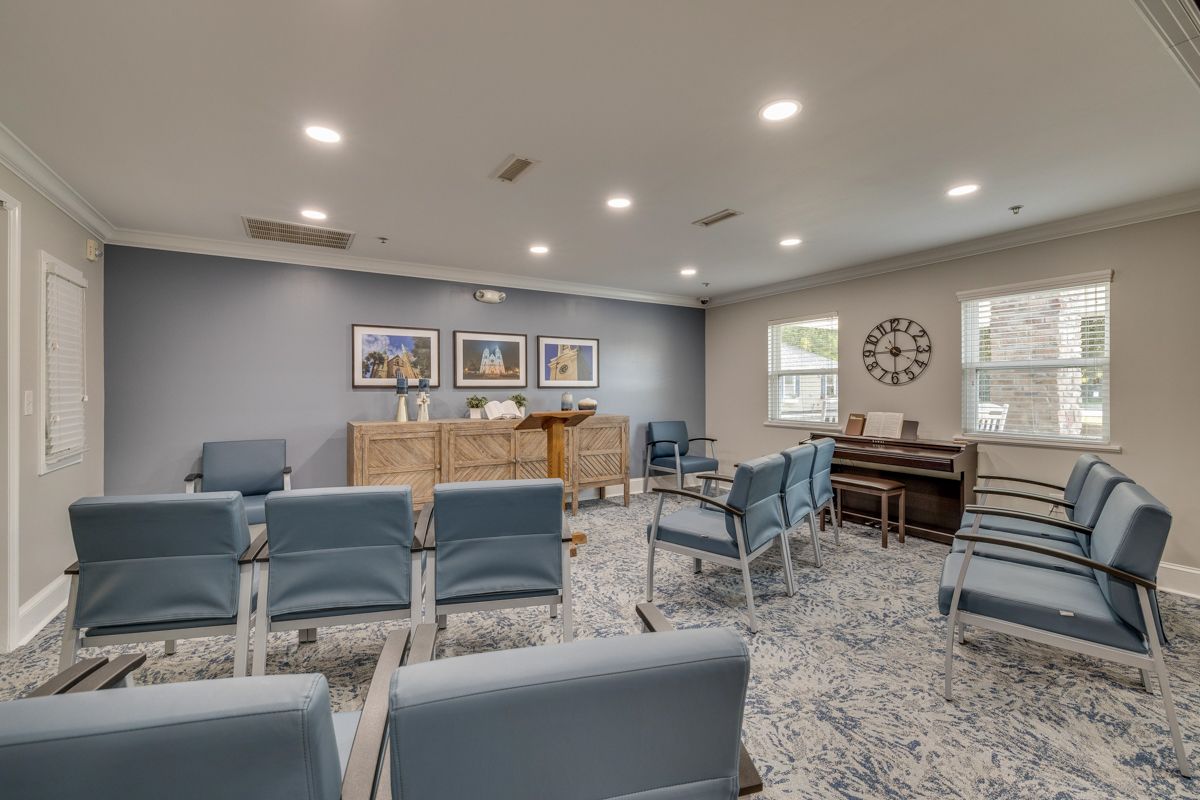 A large room with blue chairs and a piano.