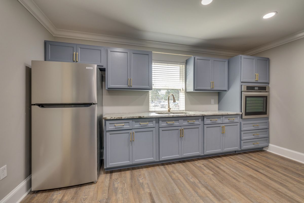 A kitchen with stainless steel appliances and blue cabinets.