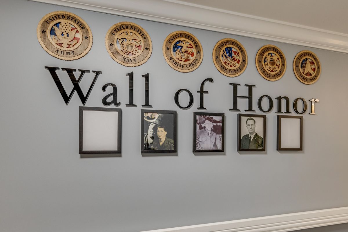 A wall of honor with pictures and plaques on it