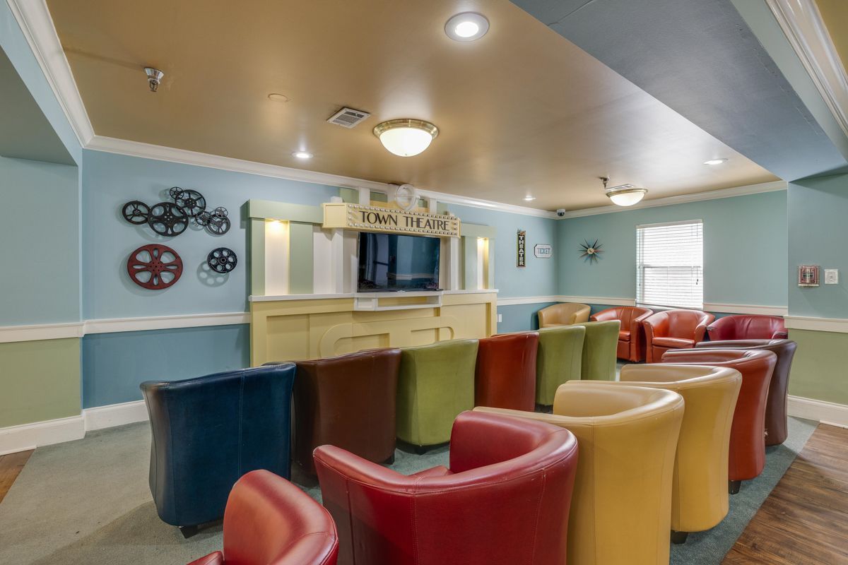 A living room filled with colorful chairs and a television.