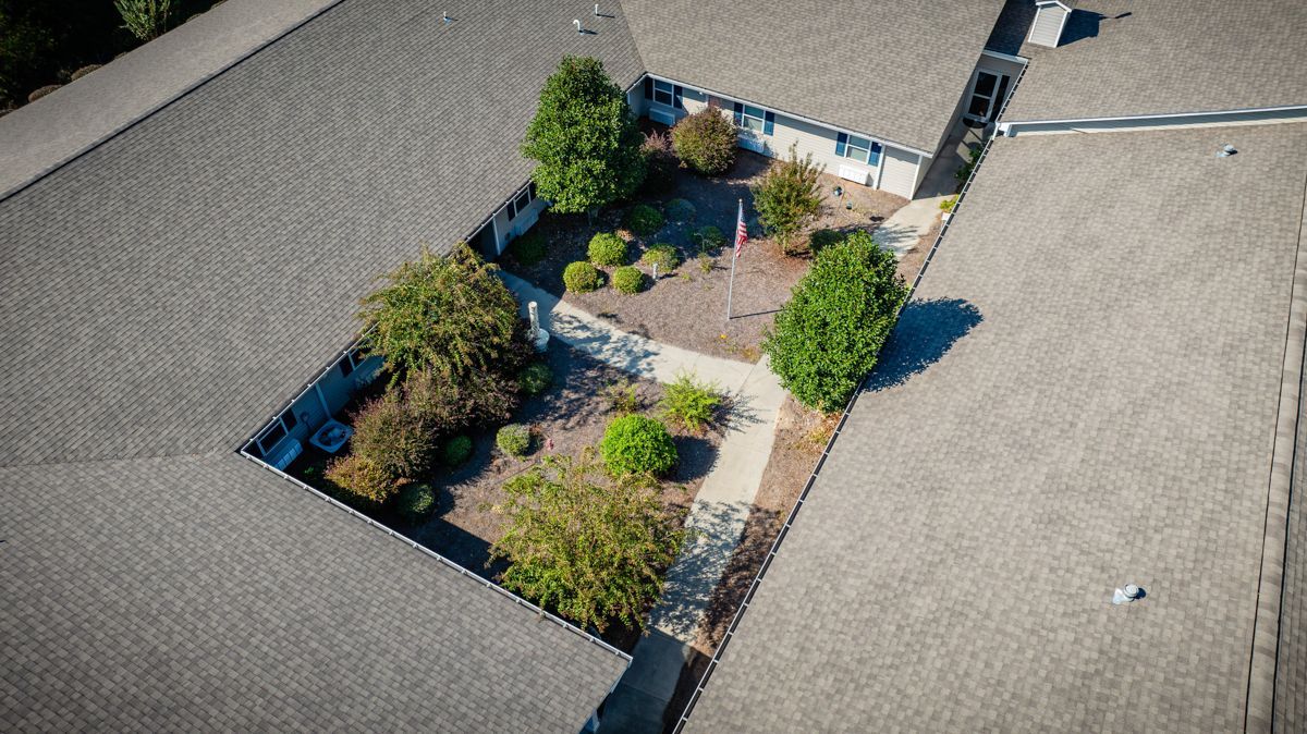 An aerial view of a house with a garden in the middle of it.
