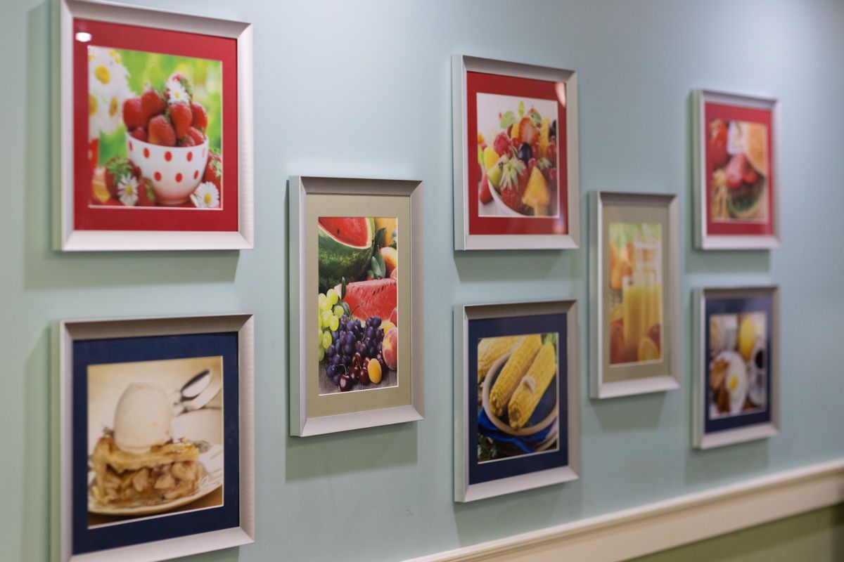 A row of framed pictures of fruits and vegetables on a wall