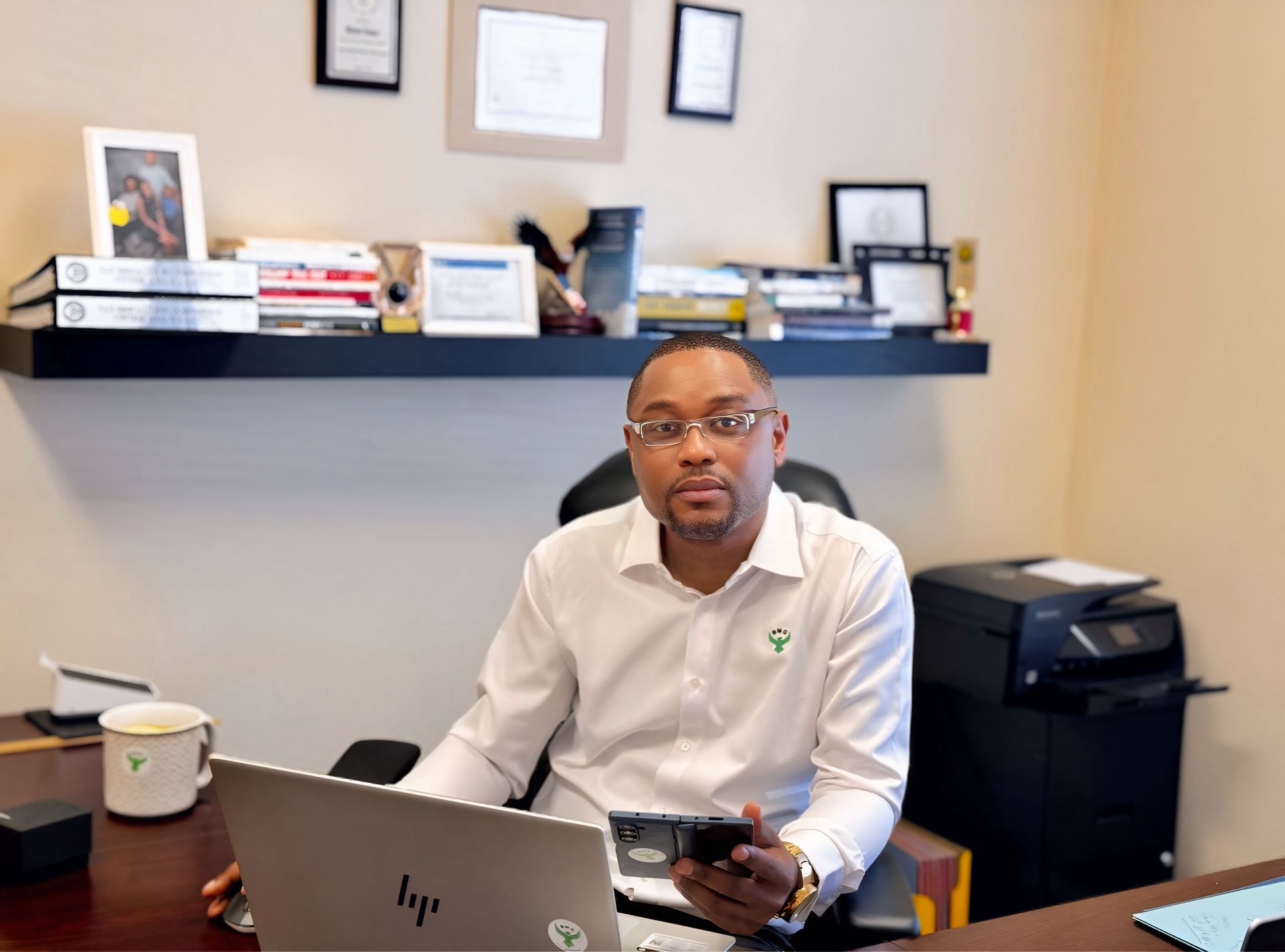 A man is sitting at a desk in front of a laptop computer.