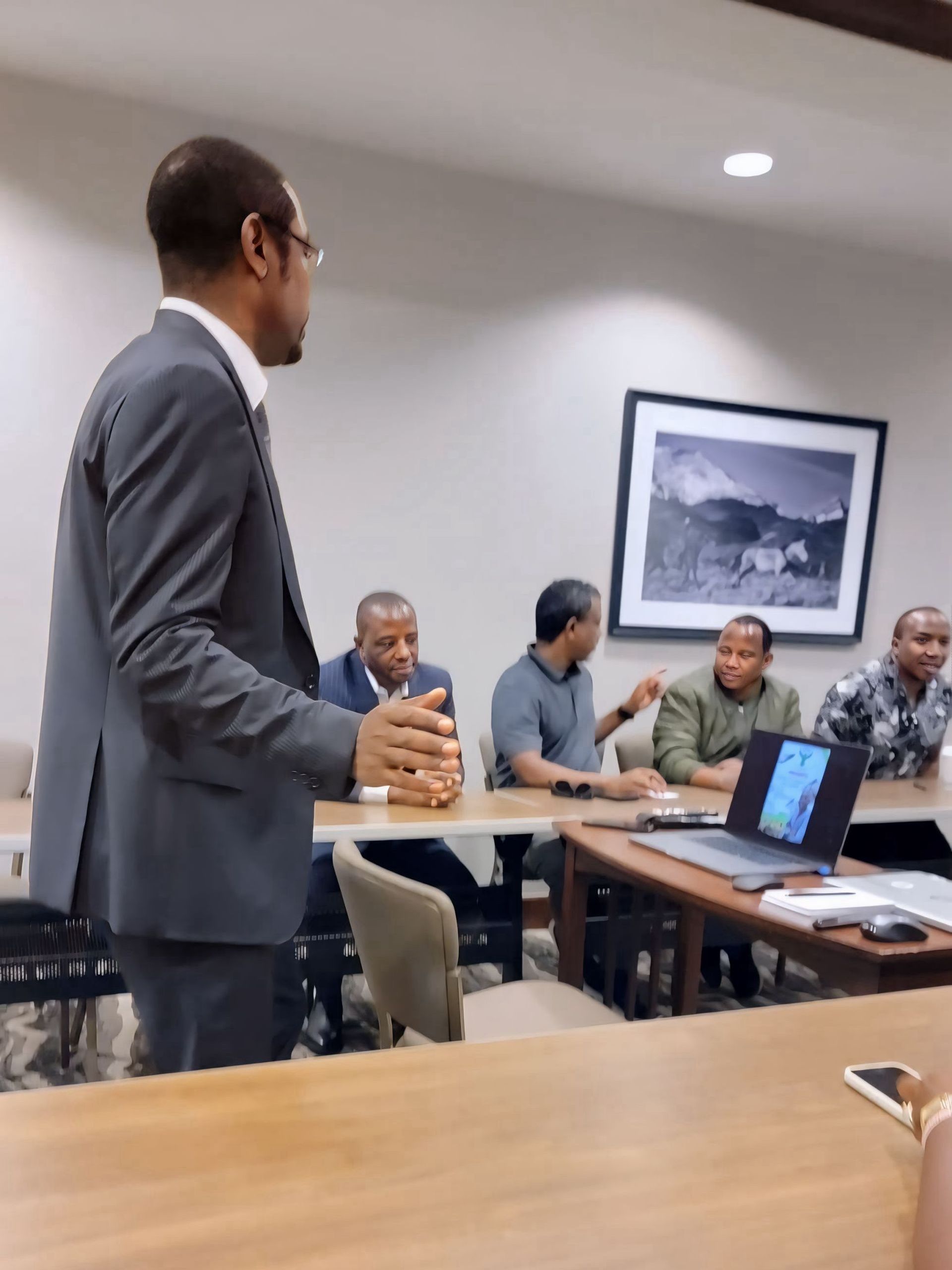 A man in a suit is giving a presentation to a group of people