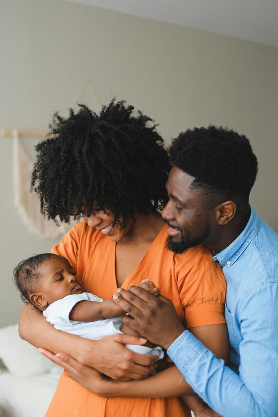 A man and a woman are holding a baby in their arms.