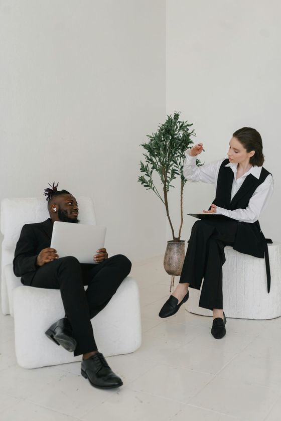 A man is sitting in a chair talking to a woman who is sitting in a chair.