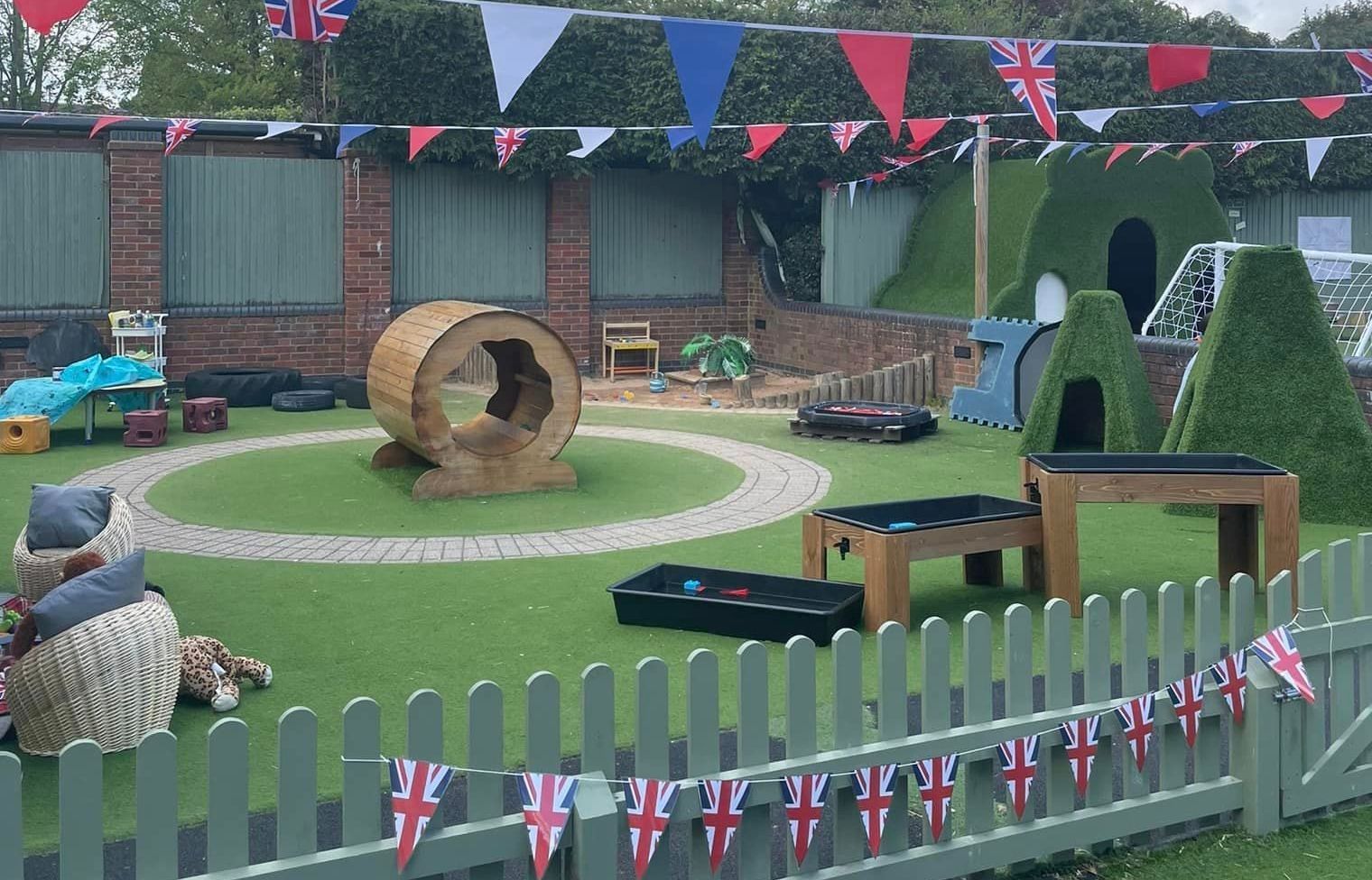 A playground with a fence and flags hanging from it