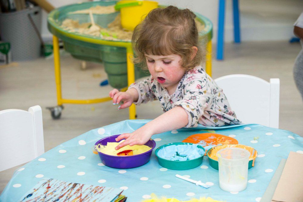 baby boy touching paint colours