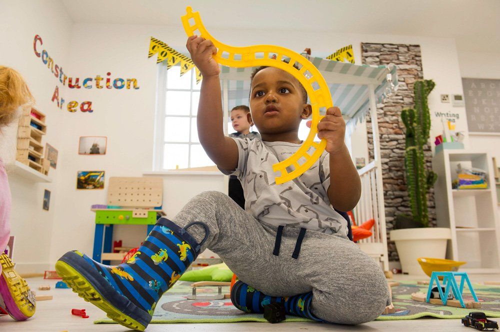 boy playing with his toy train track