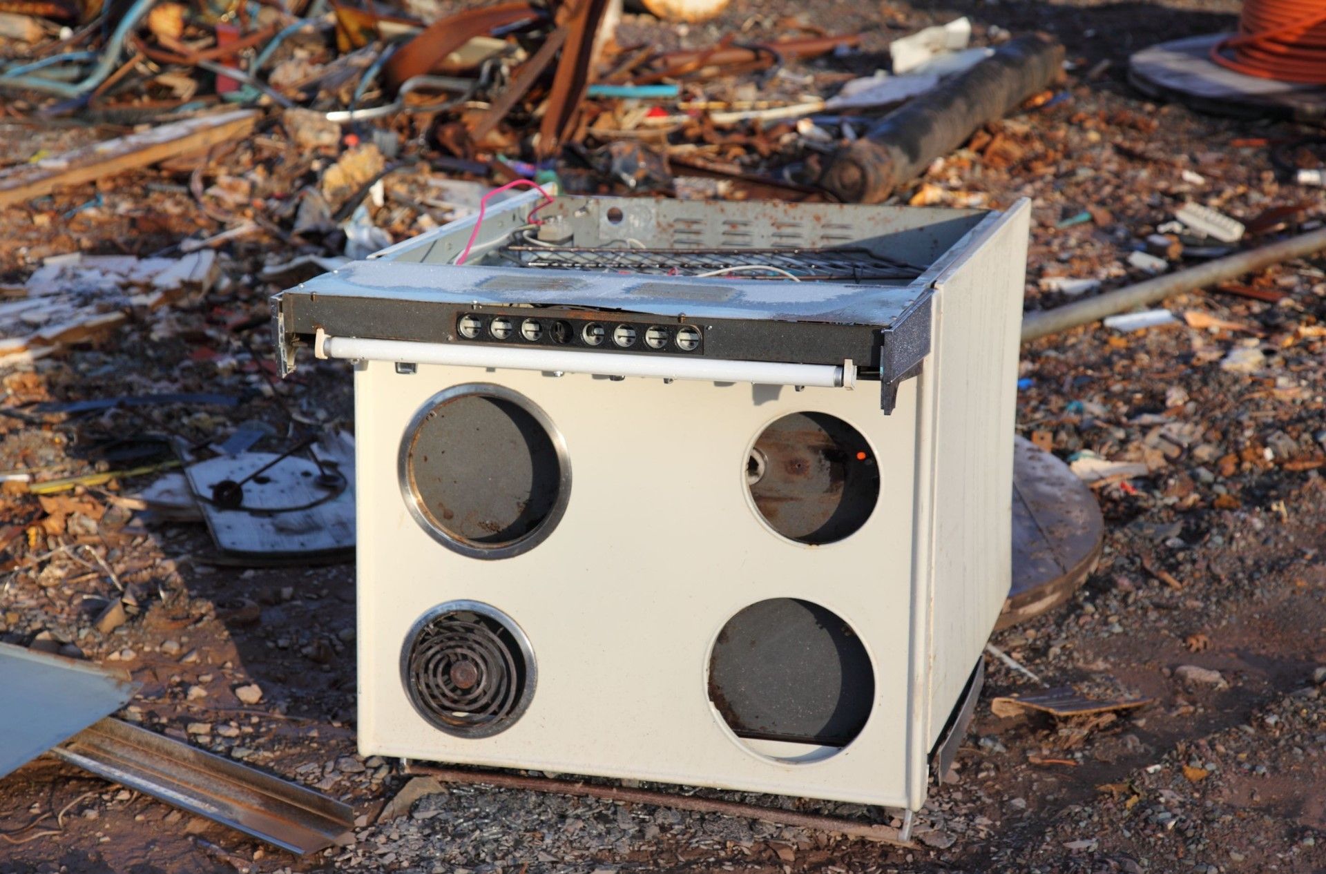 Mac's Junk Removal | An old stove is sitting on the ground in a pile of trash.