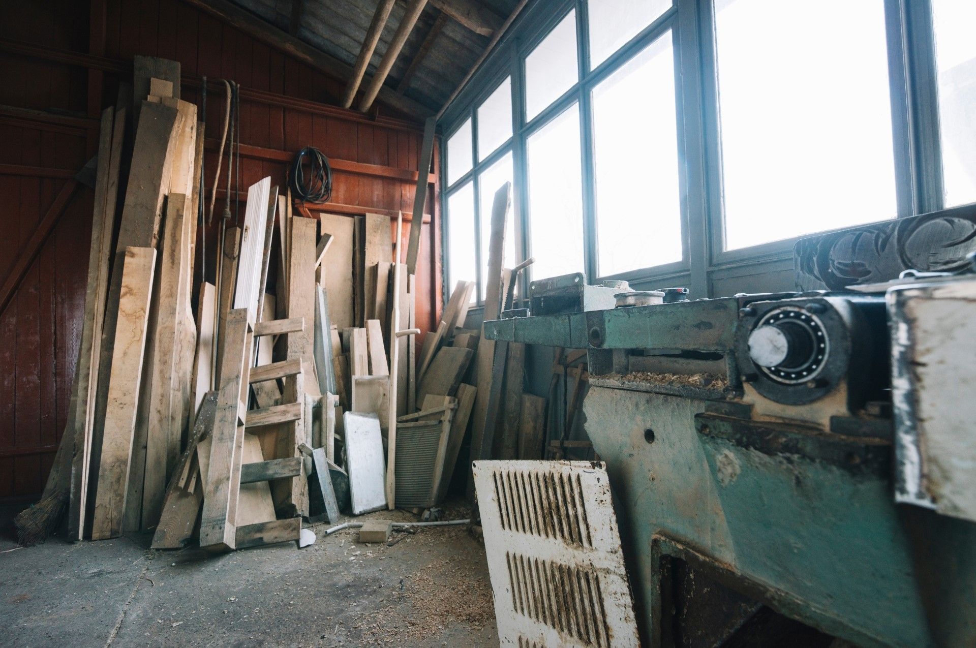 Mac's Junk Removal | A warehouse filled with wooden boards and a machine.