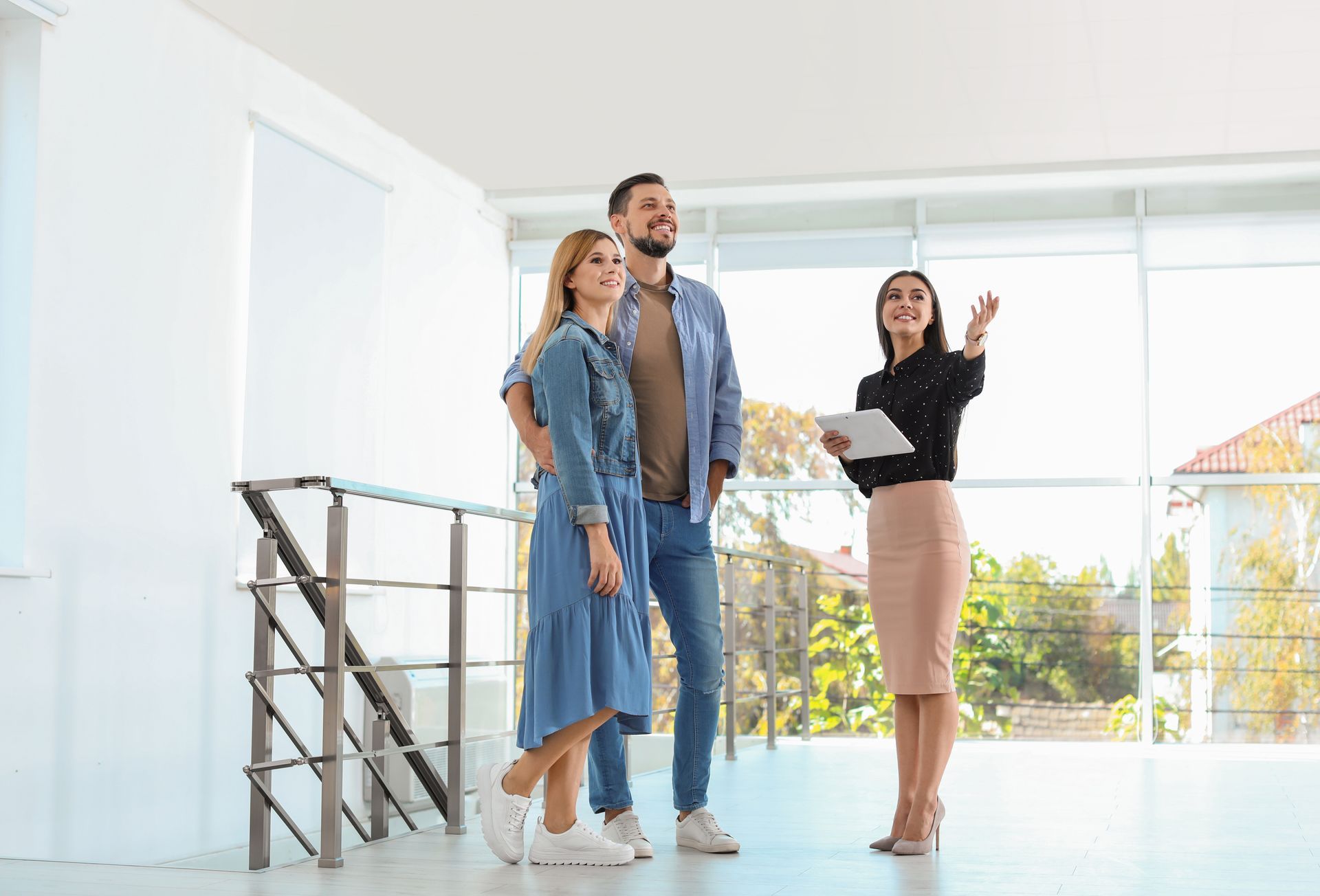Real estate broker showing a new house to couple.
