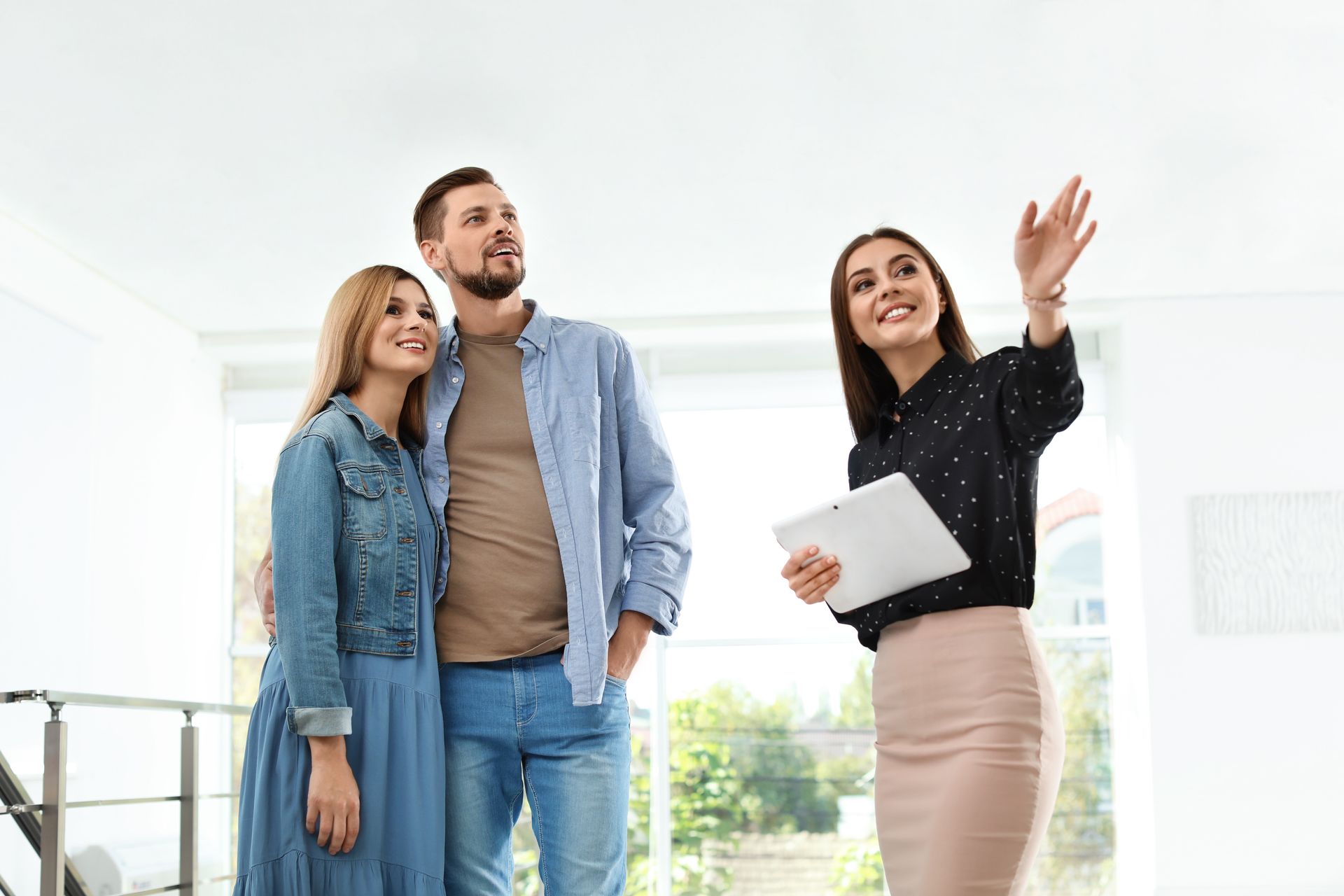 Real estate broker showing new house to couple.