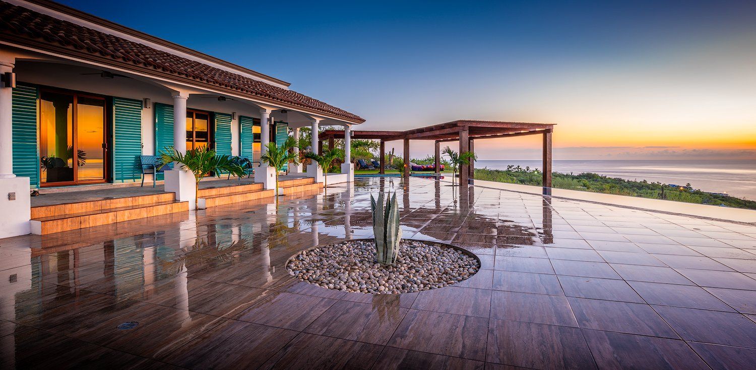 A large house with a swimming pool and a view of the ocean.