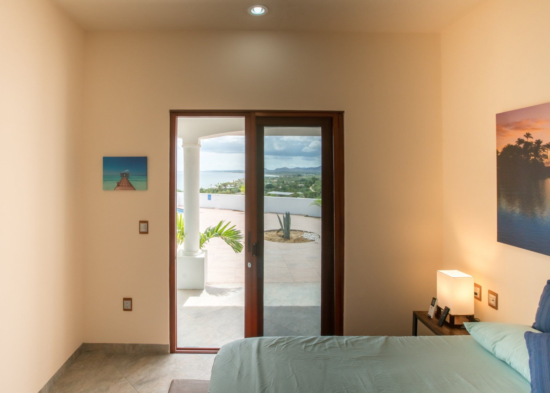 A bedroom with a bed and a sliding glass door leading to a balcony.