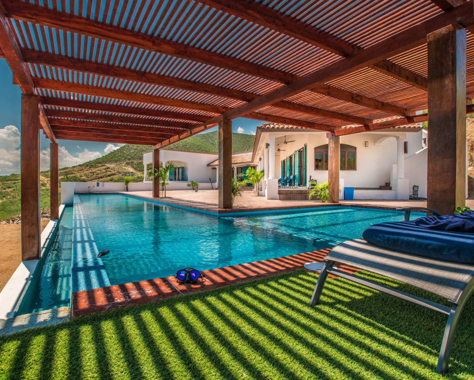 A large swimming pool with a pergola over it
