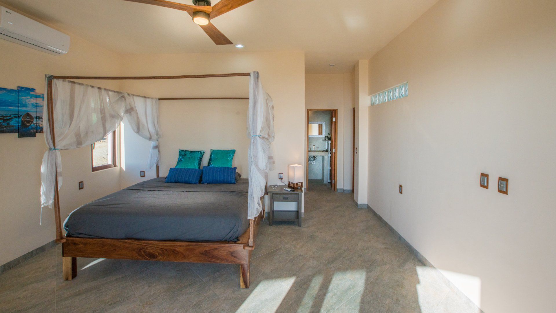 A bedroom with a canopy bed and a ceiling fan.