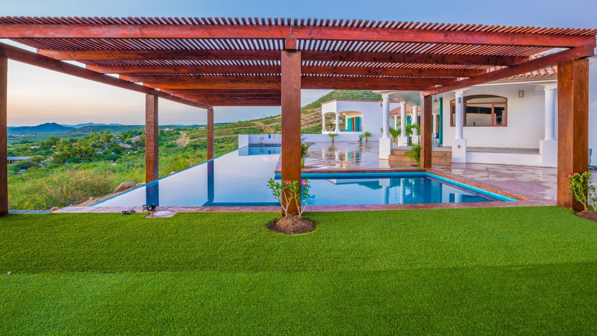 There is a large swimming pool in the backyard of a house.