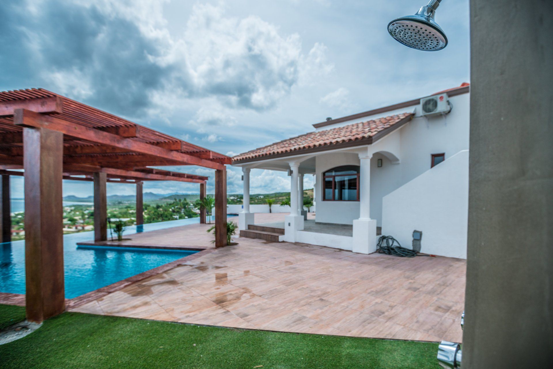 A house with a swimming pool and a shower in front of it.